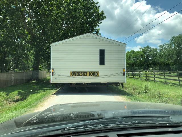 HFH trailer office being pulled down a road with and oversize load sign